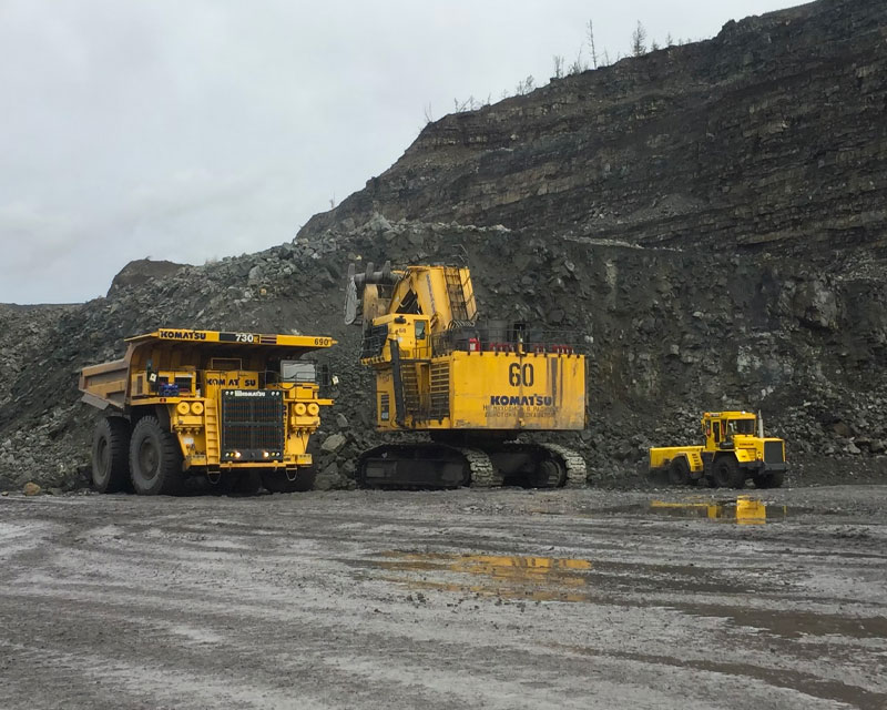 Large excavator loading ore in an open-pit mining area - IRH