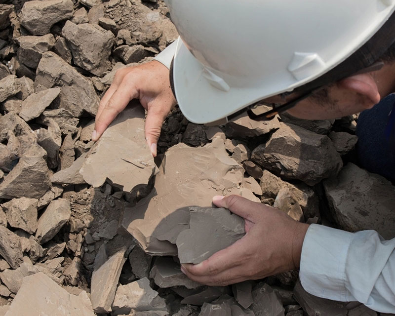 IRH geologist inspecting rock samples for mineral composition and reserve estimation